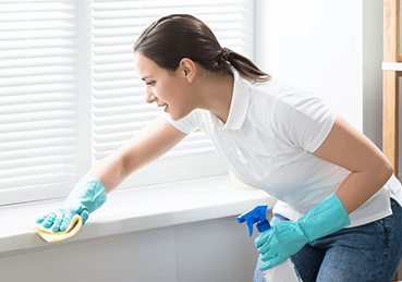 Woman quickly cleaning base of window