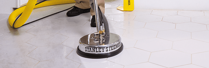 Stanley Steemer tile and grout cleaning machine being operated by certified technician