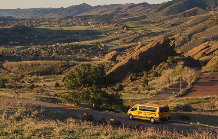 A Stanley Steemer cleaning van drives along a road in Colorado with houses off in the distance