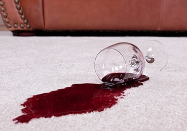 Glass of red wine spilled on carpet. 