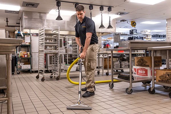 Stanley Steemer technician deep cleaning tile and grout in a restaurant